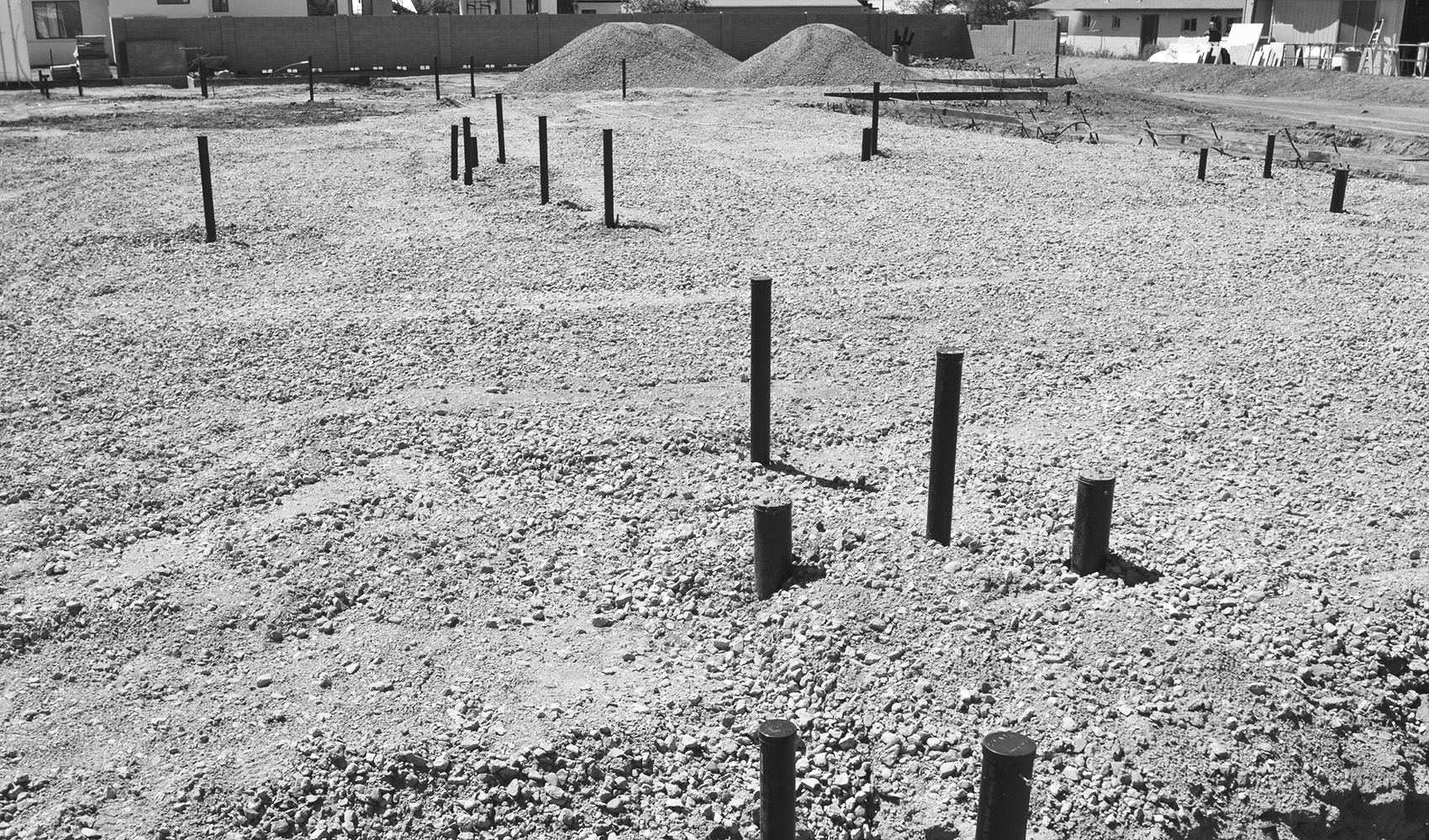 Prepared construction site pad with foundation utility locations